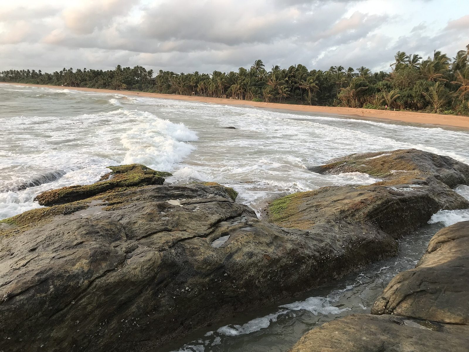 Waves breaking over rocks on Bentota beach, Sri Lanka
